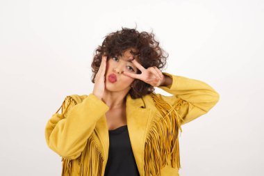 Süet ceketli güzel bir kadın stüdyo fotoğrafı çekiyor.