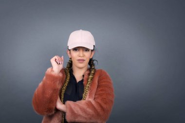 Neşeli, güzel bir genç bayanın, gri duvarın karşısında, yüzünün yanında durduğunu hayal et. İyi haberleri dinledikten sonra mutlu bir ifadeyle kameraya bakıyorum..