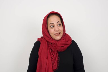 Tüh! Olgun Müslüman bir kadının portresi dişlerini sıkar ve kafasını karıştırır. Hatasını fark eder. Reklam ve promosyon geçmişiniz için fotokopi alanına karşı poz verir..