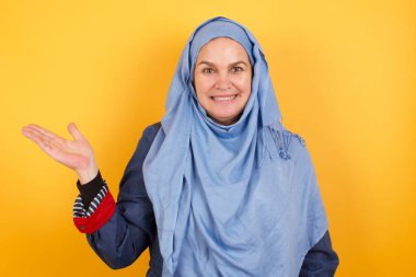 Tesettürlü orta yaşlı, mutlu Müslüman kadın der ki: Vay be, ne kadar heyecan verici, hayret verici bir ifade, boş uzayda boş bir alanda izole edilmiş arka planda bir şey gösteriyor. Reklam kavramı.