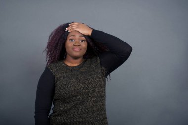 Tüh, ne yaptım ben? Güzel Afro-Amerikalı kadın, sıradan kıyafetler içinde, korkmuş ve pişmanlık dolu bir ifadeyle alnından el ele tutuşuyor. Açık havada günlük giysiler giyerek..