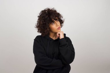 Yüz ifadeleri ve duygular. Düşünceli, genç ve güzel bir kız başının altında el ele tutuşuyor. 