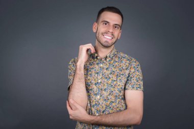 Yüzüne yakın eli gri duvarda duran neşeli, hoş, beyaz bir adam resmi. İyi haberleri dinledikten sonra kameraya mutlu bir ifadeyle bakmak. Kendinden emin adam..