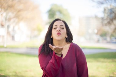 Güzel orta yaşlı Arap kadın parkta öpüşüyor.  