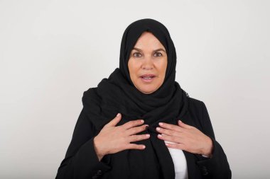 Şok olmuş, siyah tesettürlü genç Müslüman kadın ellerini göğsünde tutuyor, ağzı sonuna kadar açık, kameraya bakıyor fatura ödemeyi unuttuğunu fark ediyor, büyük, güzel, izole bir yer buluyor. Kız diyor ki: kim, ben?