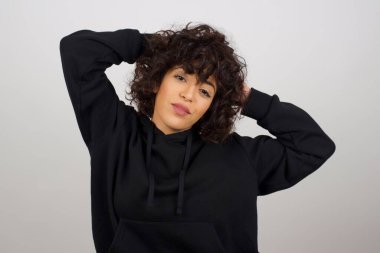 Güven ve cinsel ilişki konsepti. Çekici bir genç kızın portresi, el ele tutuşurken kendinden emin bir ifadeyle gülümsüyor..