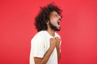 Kızıl duvara bağıran afro saçlı genç adam.   