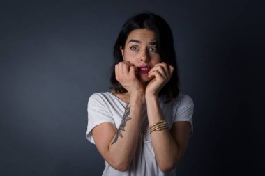 Endişe. Güzel, genç, beyaz bir kadının kavramsal görüntüsü. Ağzını elleriyle kaplıyor ve ayakta duruyor. 