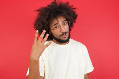 Kızıl duvarda dört parmak gösteren afro saçlı yakışıklı genç adam. 