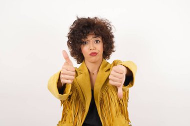 Oldukça düşünceli genç bir kadın iyiye kötüye işaret veriyor. Sıradan kıyafetler giymekten memnun değil ve etkilenmiyor..