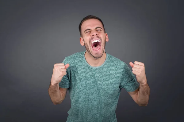 Retrato Bonito Homem Caucasiano Mostrando Punhos Isolados Sobre Parede Cinza — Fotografia de Stock