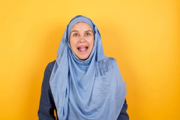 Surprised Middle Aged Muslim Woman Hijab Shrugs Shoulders Looking Sideways — Stock Photo, Image