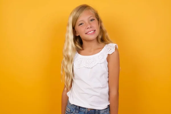 Carino Giovane Bionda Bambina Contro Giallo Studio Sfondo Sorridente — Foto Stock