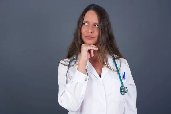 Médico Sonhador Fêmea Com Expressão Agradável Vestindo Uniforme Médico Olha — Fotografia de Stock