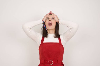 Korkunç, stres, şok. Kafasını tokalaştıran genç, duygusal bir kadının portresi. İnsani duygular, yüz ifadesi kavramı. Moda renkleri. Ön görünüm