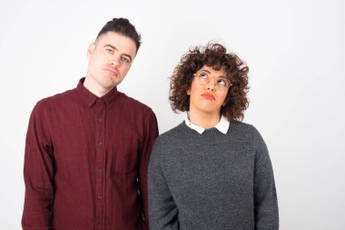 Kasvetli, sıkılmış bir çift. Yüzümü buruşturup yukarı bakıyorum, çok fazla konuşmaktan rahatsız oluyorum, yorgun hissediyorum ve gitmek istiyorum. Kızgın somurtkan kadın içeride dikiliyor..