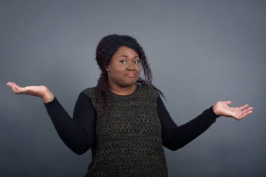 Kafası karışık ve cahil Afro-Amerikan kadın kolları açık, omuzlarını silkip, 