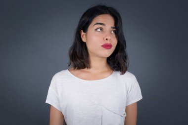 Hoş görünümlü genç bir kız öğrenci, düşünceli bir şekilde kenara bakıyor, üniversiteden sonra eylemler planlıyor, ne yapacağını hayal ediyor. Zeki kadın yeni projesini düşünüyor. Boşluğu griye kopyala.