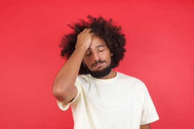 Kızıl duvarda başı ağrıyan afro saçlı genç adam.   