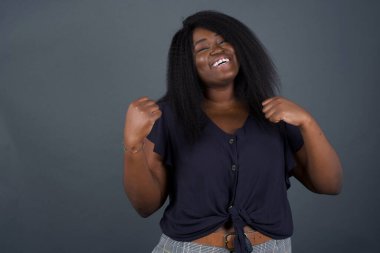 Afrikalı Amerikalı kadın başarısını ve zaferini kutluyor. Yumruklarını zevkle sıkıyor.. 