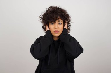 Elleriyle kulaklarını tıkayan bir kadın hard rock ya da yüksek sesle müzik dinlemek istemiyor. Avrupalı genç bir kadın gürültüyü ya da gürültüyü görmezden geliyor ya da elleriyle kulaklarını kapatıyor ve sokakta yüksek seslerden kaçınıyor.