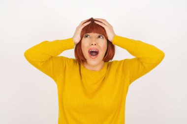 Korkunç, stres, şok. Kafasını tokalaştıran genç, duygusal bir kadının portresi. İnsani duygular, yüz ifadesi kavramı. Moda renkleri. Ön görünüm