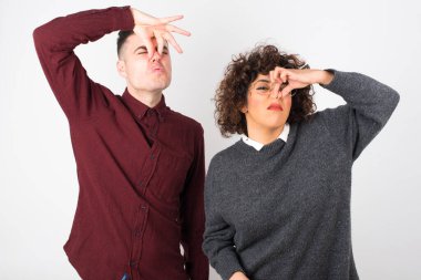 Stüdyo çekimi. Genç ve güzel bir çift burun kapatıyor.  