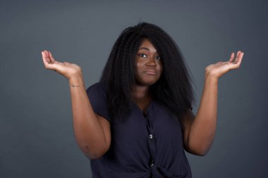 Kafası karışık ve cahil, kolları açık, omuzlarını silkip 