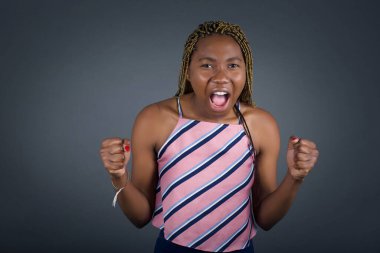 Güzel, Afro-Amerikan bir kadının portresi kameraya heyecanla bakıyor. Gri duvarda beklenmedik bir şey fark ediyor.