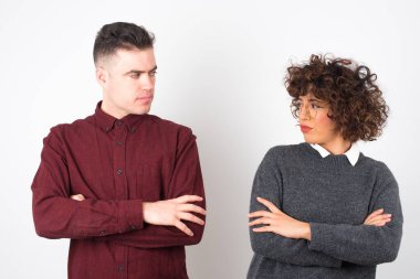 Closeup portrait displeased pissed off young couple with bad attitude, arms crossed looking sideways. Negative human emotion facial expression feelings
