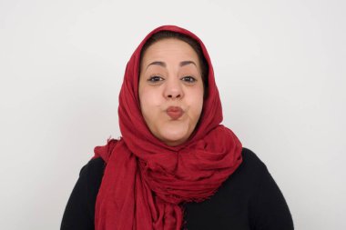 Orta yaşlı, atölyede poz veren komik yüzlü, başörtüsü takan bir Arap kadın. Havayla şişmiş ağız, çılgın bir ifade..