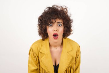 Çekici genç bir kadın ağzı açık, ağzı açık, ağzı açık bir şekilde şoke olmuş bir şekilde arkadaşının hikayesini dinlerken 