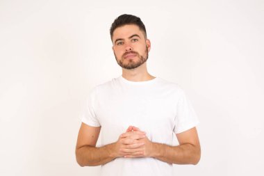 İş Konsepti - Beyaz tişört giyen yakışıklı beyaz adam gri arkaplanda kendine güvenen yüzüyle el ele tutuşuyor.