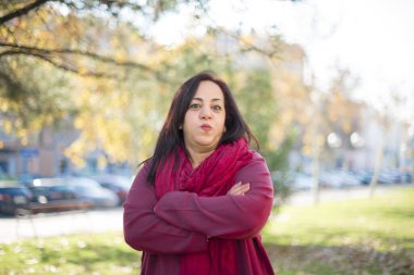 Parkta kollarını kavuşturmuş orta yaşlı güzel bir Arap kadın.  