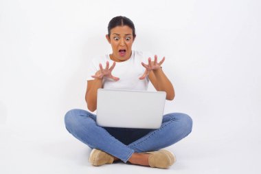 Tatmin olmayan kadın model kaşlarını çatar, iğrenç bir ifadeye sahiptir, dilini gösterir, itaatsizliğini gösterir, birilerine kızar, reddedenler bir şeyler yapar. İnsanlar ve olumsuz yüz ifadeleri. Dizüstü bilgisayar kullanan güzel bir Arap kadın.