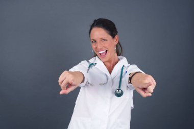 Gri arka planda izole edilmiş, iki parmağıyla kamerayı işaret ederek, 