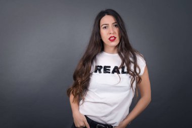 Gri arka planda poz veren güzel kadın.  