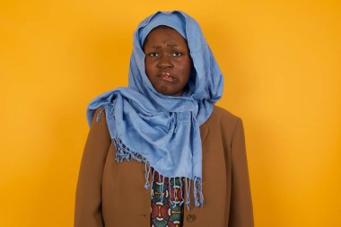 Güzel, Afro-Amerikalı Müslüman bir kadın sabırsız bir ifadeyle kameraya bakıyor. Düşünceli.