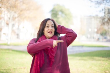 Güzel orta yaşlı Arap kadın parkı işaret ediyor.  