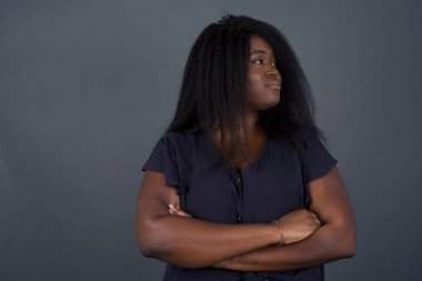 İçeride kollarını kavuşturmuş, üzgün, Afro-Amerikan bir kadının görüntüsü. Kötü haberleri dinledikten sonra hayal kırıklığına uğramış bir ifadeyle bakıyorum.. 