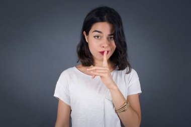 Sırrımı söyleme ya da yüksek sesle konuşma, lütfen! Duygusal olarak şaşırmış bir öğrenci sessiz olur, sessiz olur musun diye sorar. Sırrını açıklamaktan korkar ve gri stüdyo duvarına karşı durur..