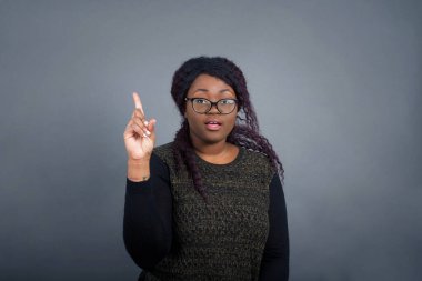 Bir parmağıyla yukarı bakıp gülümseyen Afro-Amerikan kadınının yakın plan portresi. Bir fikrim var. Cevabı ya da çözümü biliyorum..