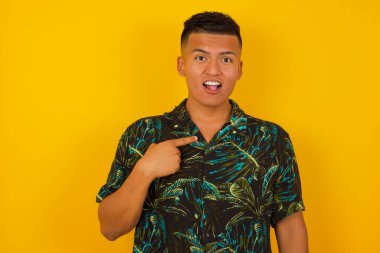 Şaşırmış yakışıklı erkek öğrenci sersemlemiş durumda, şaşkın bir şekilde kendini parmağıyla işaret ederek 