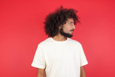 Kızıl duvara bakan afro saçlı genç adam.   