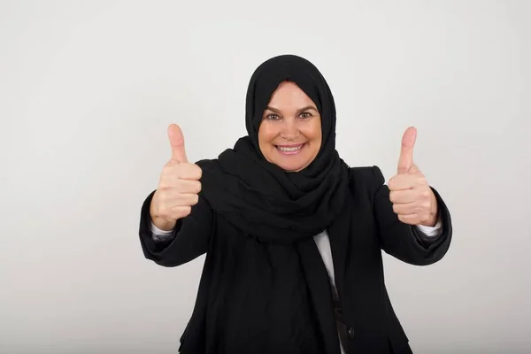 よくやった 黒いヒジャーブの幸せな笑顔のイスラム教徒の女性の肖像画は 屋内で立っているジェスチャーを2つの親指を与えます ポジティブな人間の感情の表情ボディ言語 おかしい女の子 — ストック写真