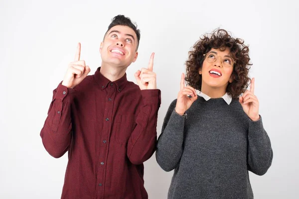 Young Couple Exclaiming Excitedly Pointing Both Index Fingers Indicating Something — Stock Photo, Image