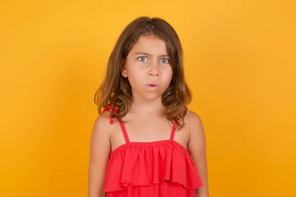 Beautiful Confused Little Girl Wearing Red Dress Posing Yellow Background — Stock Photo, Image