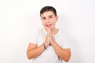 Güzel bir çocuğun yatay portresi avuç içlerini bir arada tutar, mutlu bir ifadesi vardır. Çekici erkek merhamet diliyor..