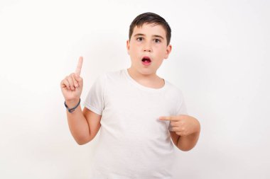 Pozitif çocuk bir şeyler gösteriyor. Bir eli göğsünde ve diğer eliyle işaret ediyor.. 