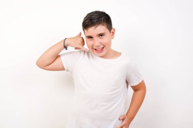 Gündelik giysiler içindeki çekici genç erkek telefon konuşmasını taklit ediyor, cep telefonu tutar gibi elini kulağına yaklaştırıyor, kendine güvenen bir yüz ifadesi var. Ara beni.!